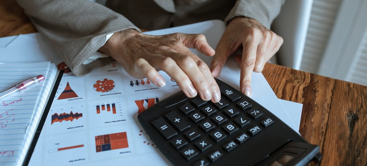 kobiece ręce liczące coś na kalkulatorze